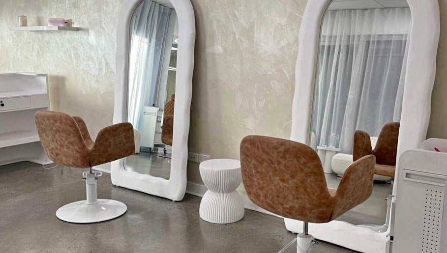 Modern salon interior at Aloha Hair & co, Varsity Lakes, Queensland, AU showcasing stylish chairs and large mirrors.