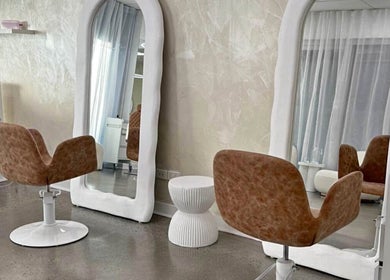 Modern salon interior at Aloha Hair & co, Varsity Lakes, Queensland, AU showcasing stylish chairs and large mirrors.