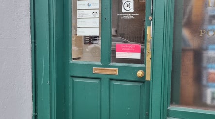 Entrance of The Peak Wellness Studio, Dublin, County Dublin, IE, showcasing a green door with wellness signs.