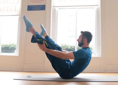 A man practicing yoga at The Peak Wellness Studio, Dublin, County Dublin, IE, in a bright, serene room.
