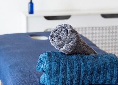 Relaxing massage setup at The Peak Wellness Studio, Dublin, County Dublin, IE with neatly rolled towels.