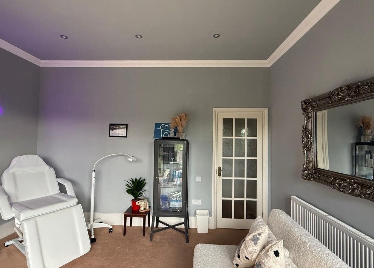 Elegant treatment room at Pearl Brite, Newport, Wales, GB with white chair and decor.