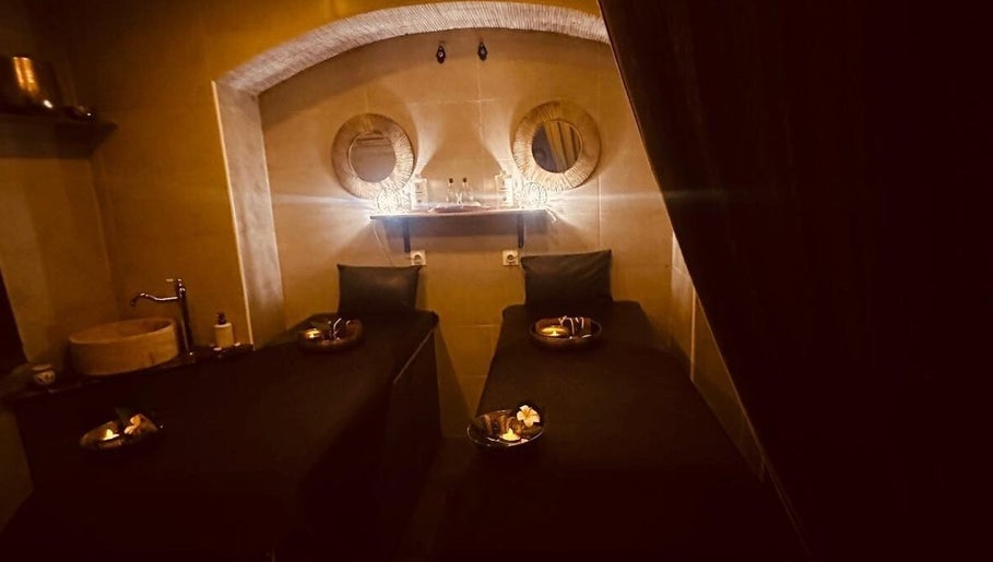 Salle de massage apaisante à Gold Empire Spa, Paris, Île-de-France, FR, avec lits jumeaux et décor chaleureux.