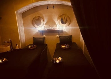 Salle de massage apaisante à Gold Empire Spa, Paris, Île-de-France, FR, avec lits jumeaux et décor chaleureux.