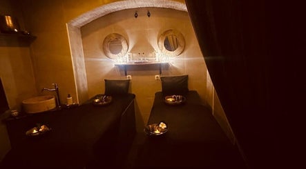 Salle de massage apaisante à Gold Empire Spa, Paris, Île-de-France, FR, avec lits jumeaux et décor chaleureux.
