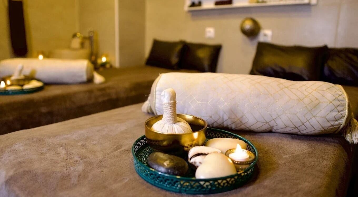 Luxe table de massage chez Gold Empire Spa, Paris, Île-de-France, FR avec bougies et coussins confortables.