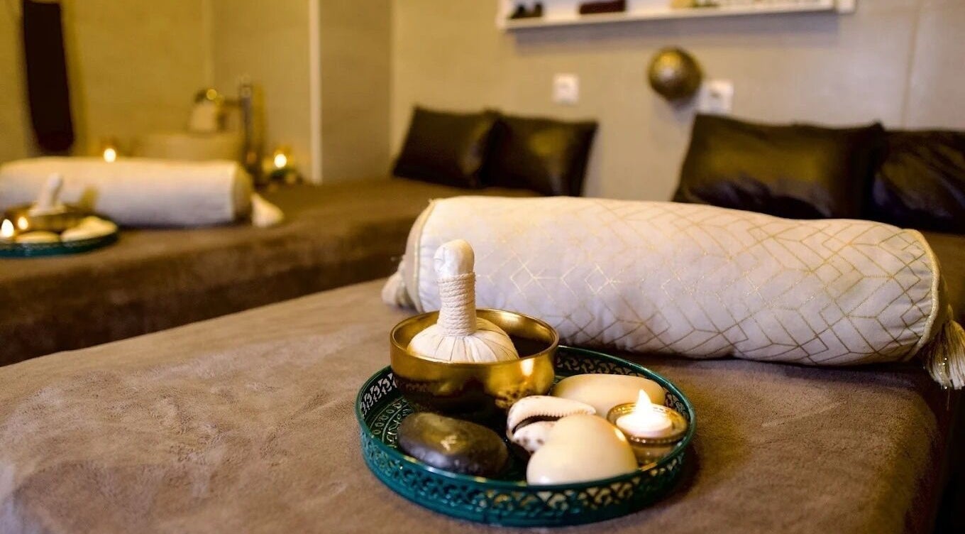 Luxe table de massage chez Gold Empire Spa, Paris, Île-de-France, FR avec bougies et coussins confortables.