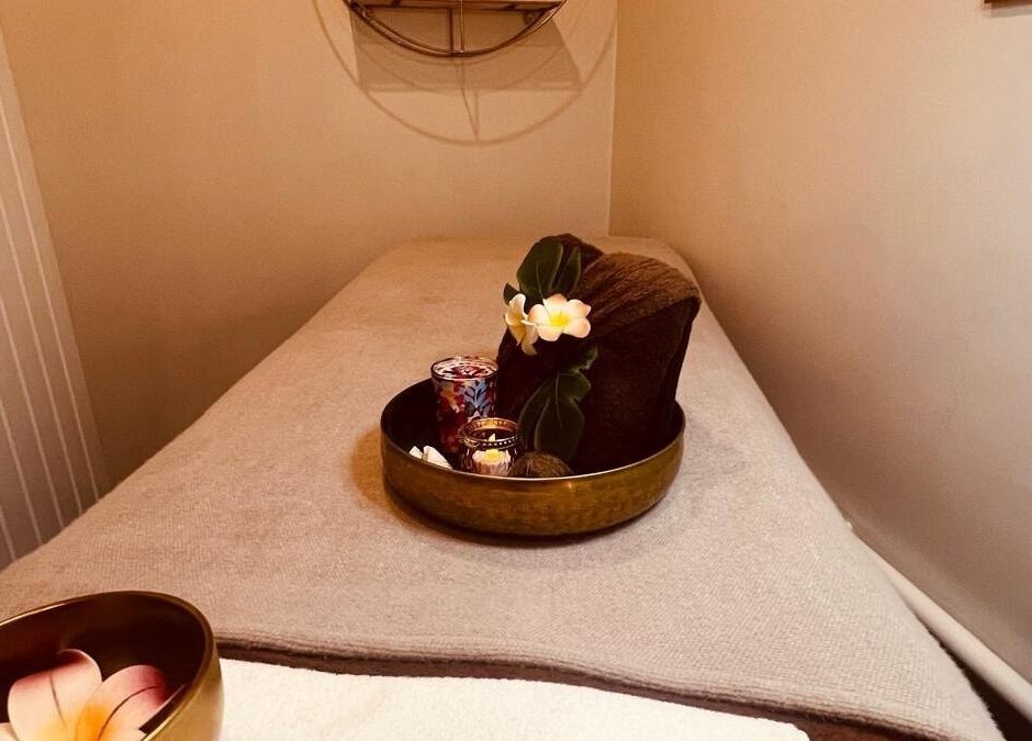 Table de massage apaisante au Gold Empire Spa, Paris, Île-de-France, FR. Ambiance zen et fleurs délicates.