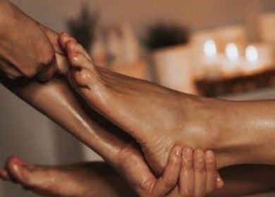 Foot massage at Harmony Aesthetic & Spa, Goose Creek, South Carolina, US with candles in the background.