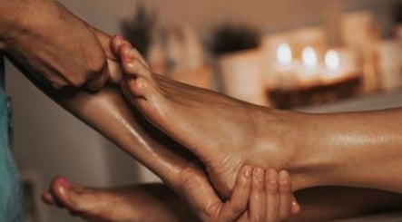 Foot massage at Harmony Aesthetic & Spa, Goose Creek, South Carolina, US with candles in the background.