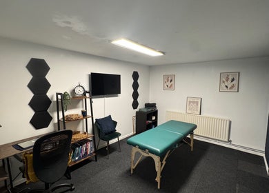 Cozy therapy room at A&M Physiotherapy, Kenilworth, England, GB, featuring treatment bed and modern decor.