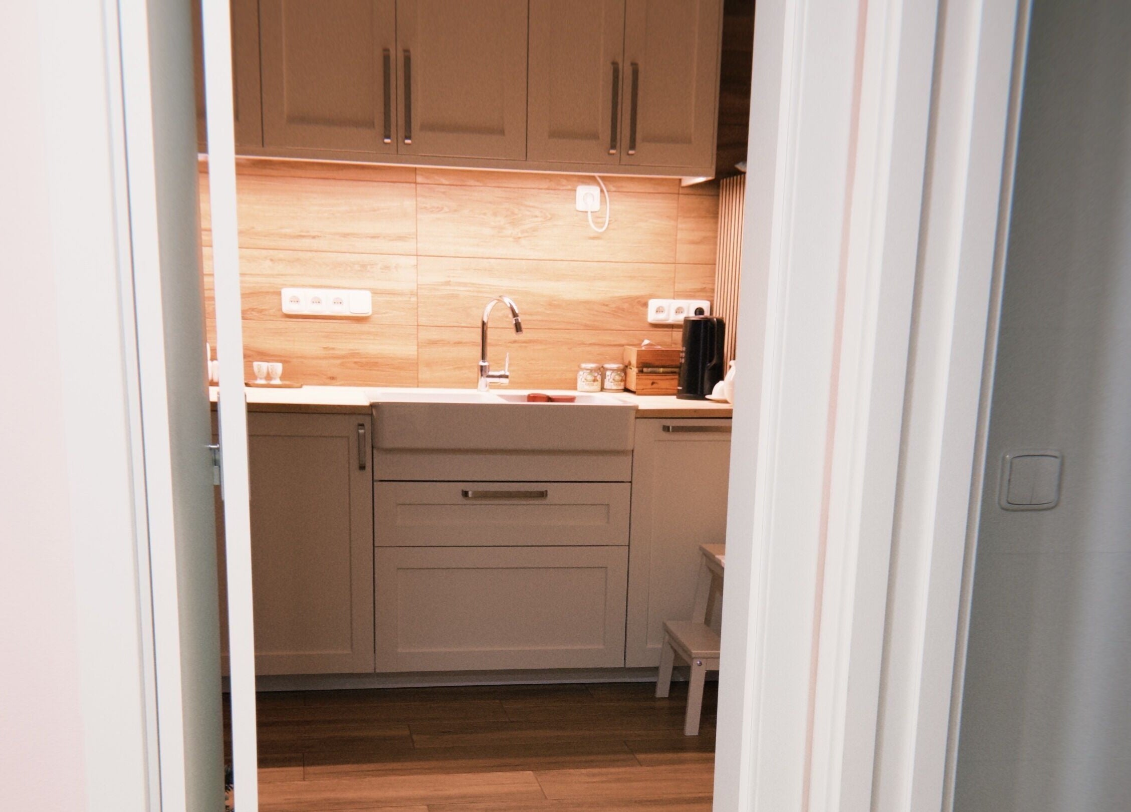 Modern kitchen at Bali & Sport Massage, Hlavní Město Praha, CZ with wooden accents and sleek cabinetry.