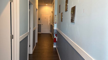 Tranquil hallway at Massage Randolph in Colesville, Maryland, US, featuring calming decor and wooden flooring.