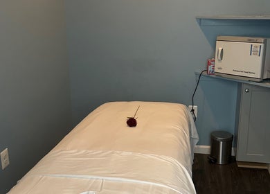 Cozy massage room at Massage Randolph, Colesville, Maryland, US, featuring a plush bed and towel warmer.