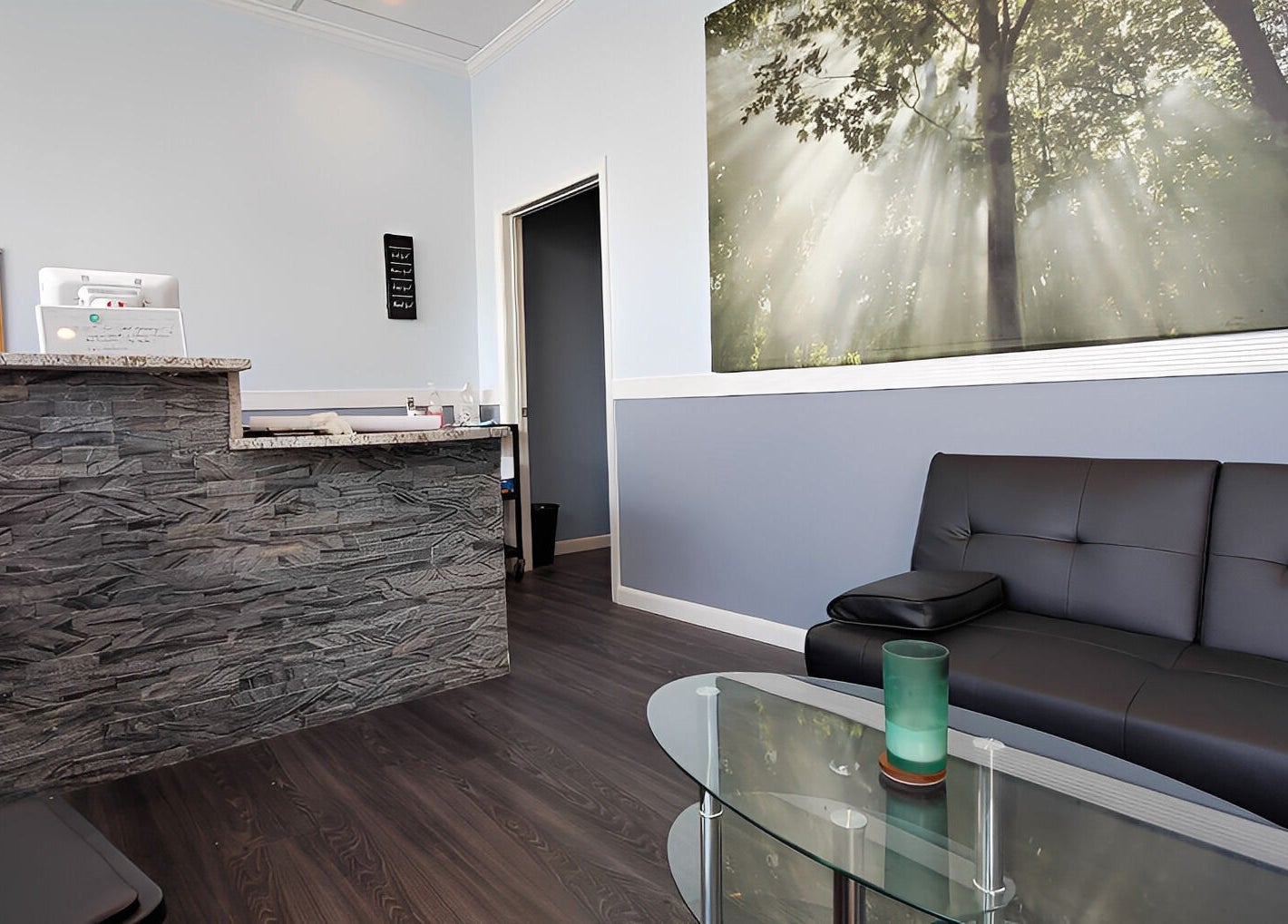 Welcoming reception area at Massage Randolph in Colesville, Maryland, US, featuring a sleek sofa and stone counter.
