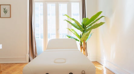 Sala de massagem iluminada no Sayo - Massage & Beauty, Lisboa, Lisboa, PT, com planta decorativa.