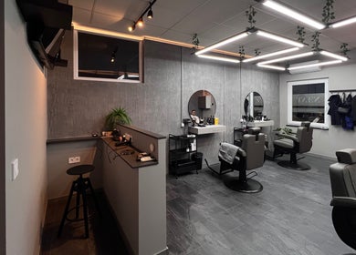 Neat Male Hairstudio elegáns belső tere Budapesten, Magyarországon, modern székekkel és stílusos tükrökkel.