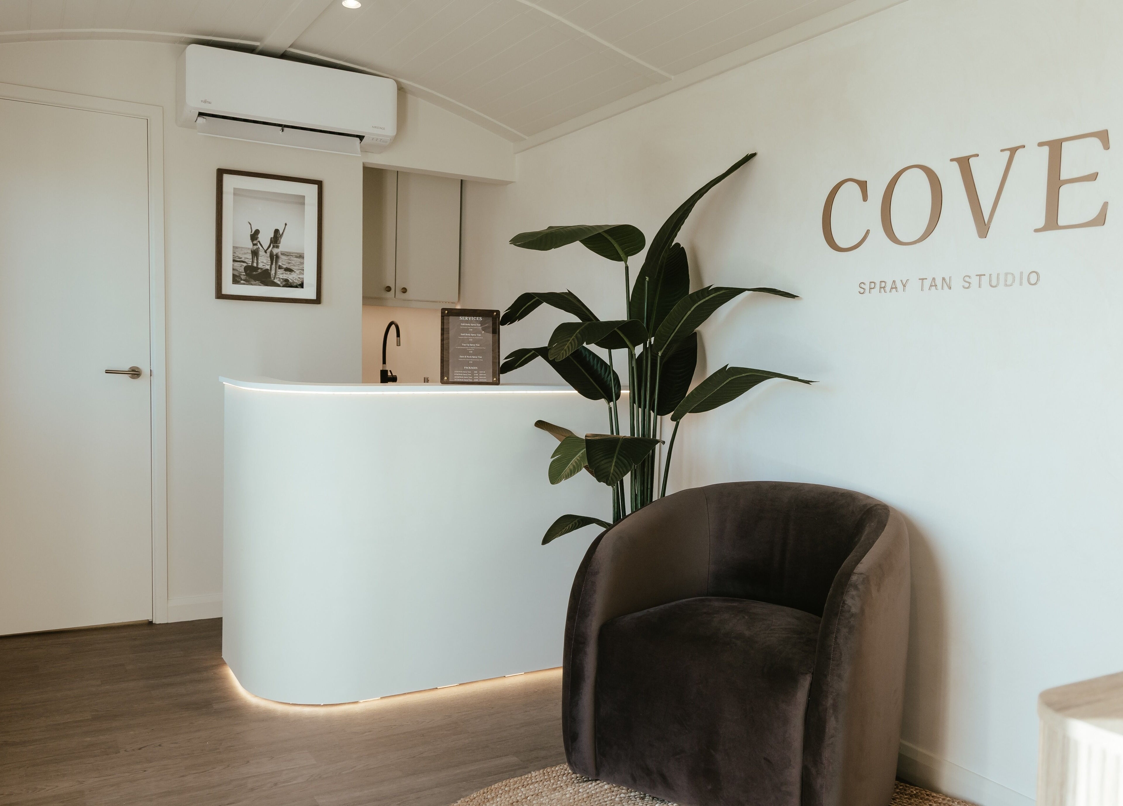 Elegant reception at COVE - Spray Tan Studio, Hethersett, England, GB with modern decor and lush plant.