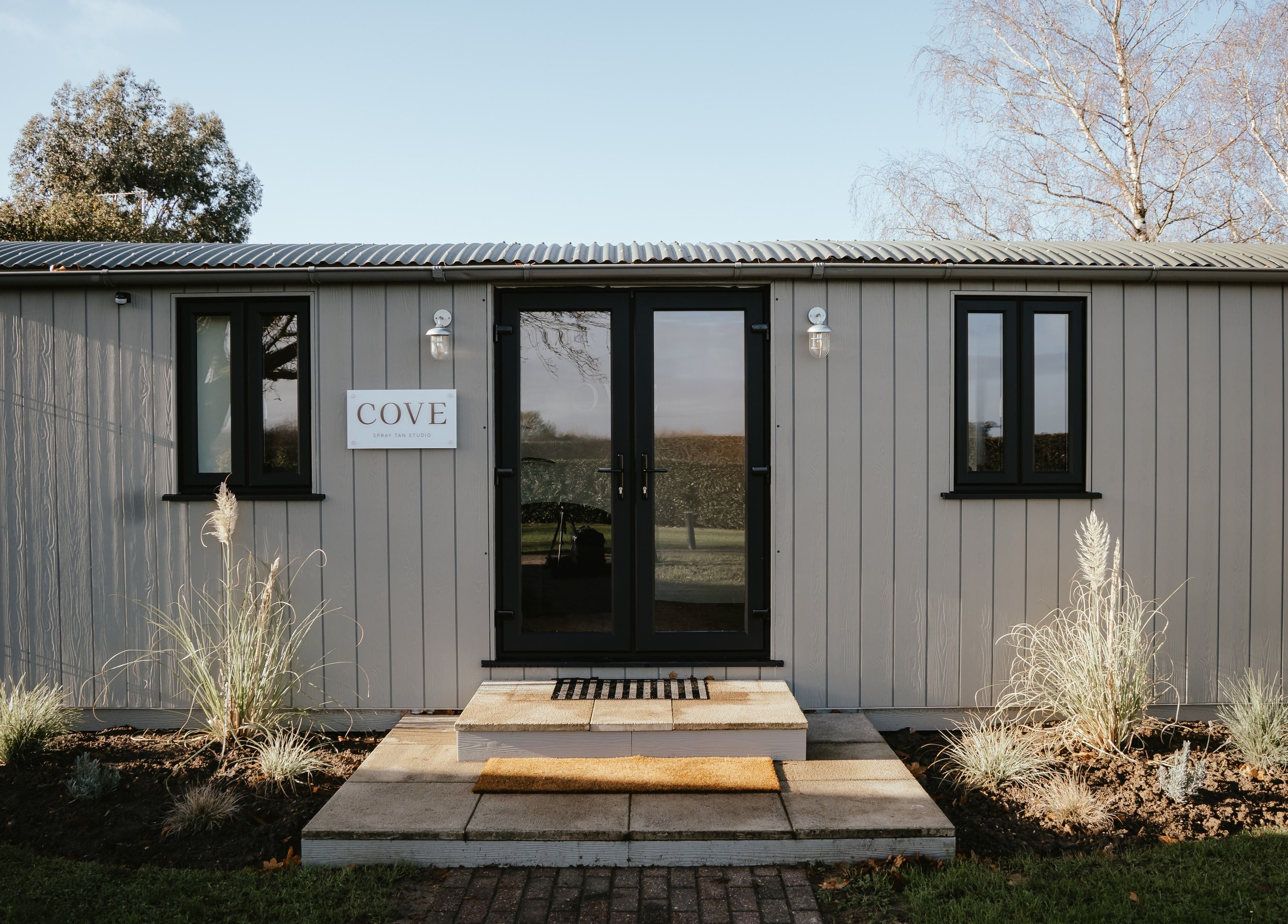 Entrance of COVE - Spray Tan Studio in Hethersett, England showcasing modern facade and welcoming design.