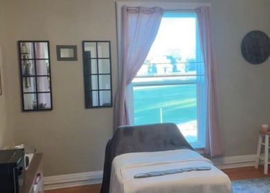 Relaxing treatment room at L.D Esthetics, Quincy, Illinois, US, featuring a massage table near a sunlit window.