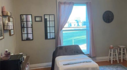 Relaxing treatment room at L.D Esthetics, Quincy, Illinois, US, featuring a massage table near a sunlit window.