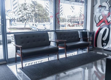 Modern waiting area at London Clippers in Lake Zurich, Illinois, US with stylish black seating and wall art.