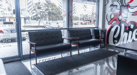 Modern waiting area at London Clippers in Lake Zurich, Illinois, US with stylish black seating and wall art.
