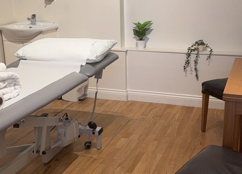 Relaxing treatment room at Rehab Joy with a massage table, London, England, GB. Modern decor enhances the ambiance.