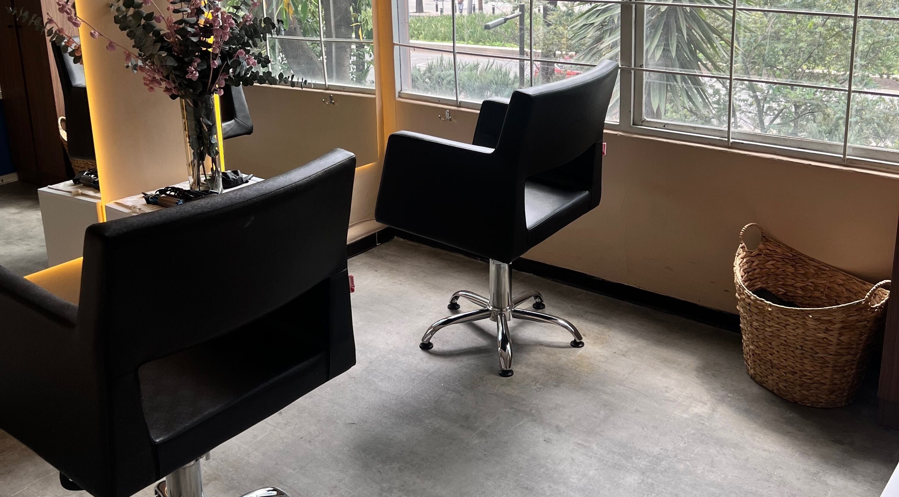Modern salon chairs at The Room Hair Brows Makeup in Ciudad De México, MX, offering stylish comfort.