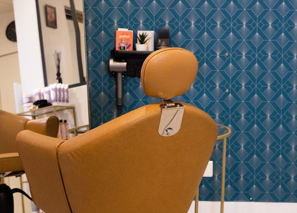 Fauteuil élégant à Studio - Rue Clauzel, Paris, Île-de-france, FR, devant un mur bleu.