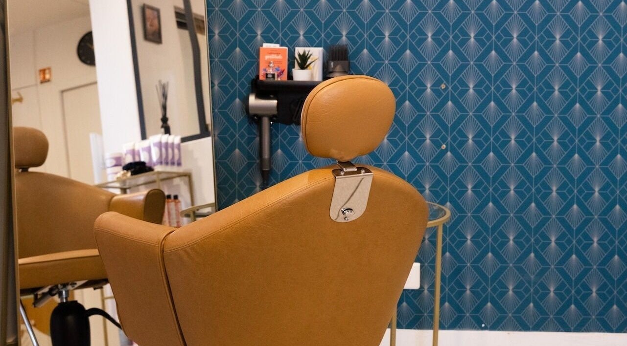 Fauteuil élégant à Studio - Rue Clauzel, Paris, Île-de-france, FR, devant un mur bleu.