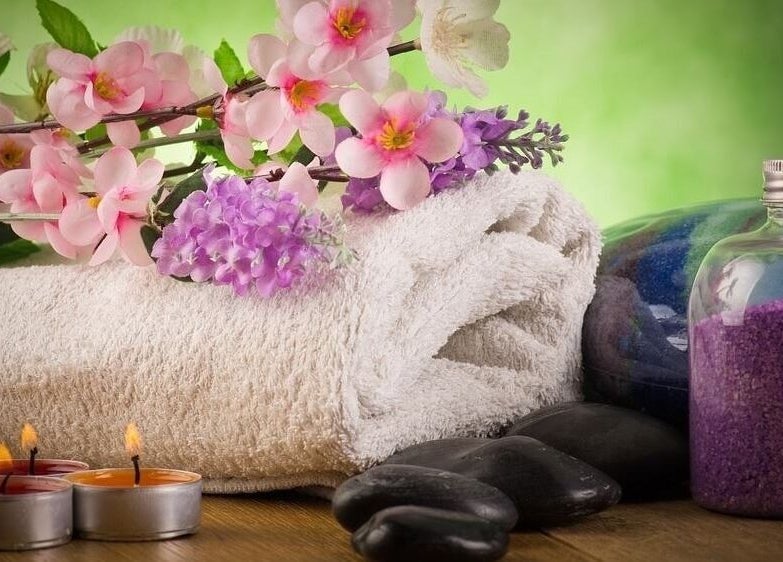 Relaxing spa setup with flowers, candles, and purple salts at CS Sanctuary Wellness Spa, Plantation, Florida, US.