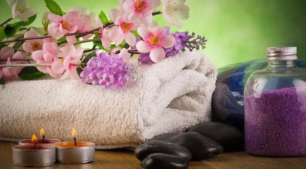 Relaxing spa setup with flowers, candles, and purple salts at CS Sanctuary Wellness Spa, Plantation, Florida, US.