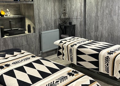 Relaxing massage room at ND Skin Clinic, Prestwich, England, GB with twin treatment beds and elegant decor.