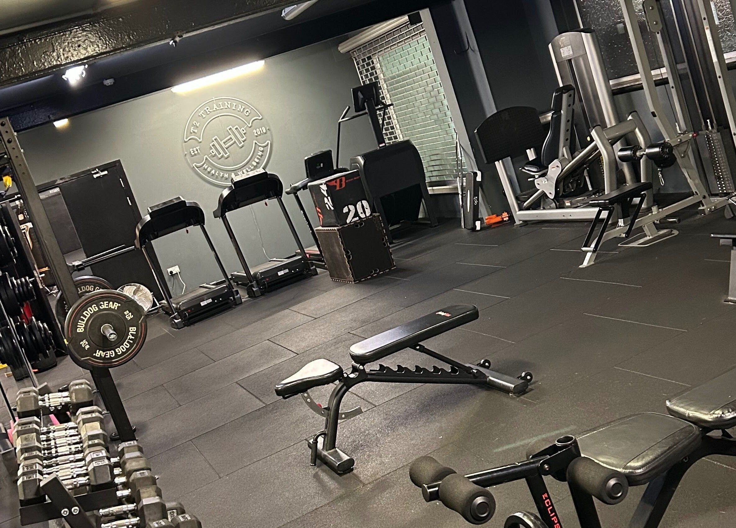 Modern gym with free weights at ProBuild Physiotherapy, Neath, Wales, GB showcasing workout equipment.