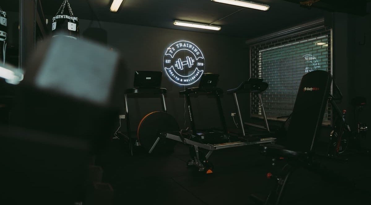 ProBuild Physiotherapy gym setup in Neath, Wales, GB showcasing fitness equipment and neon logo.