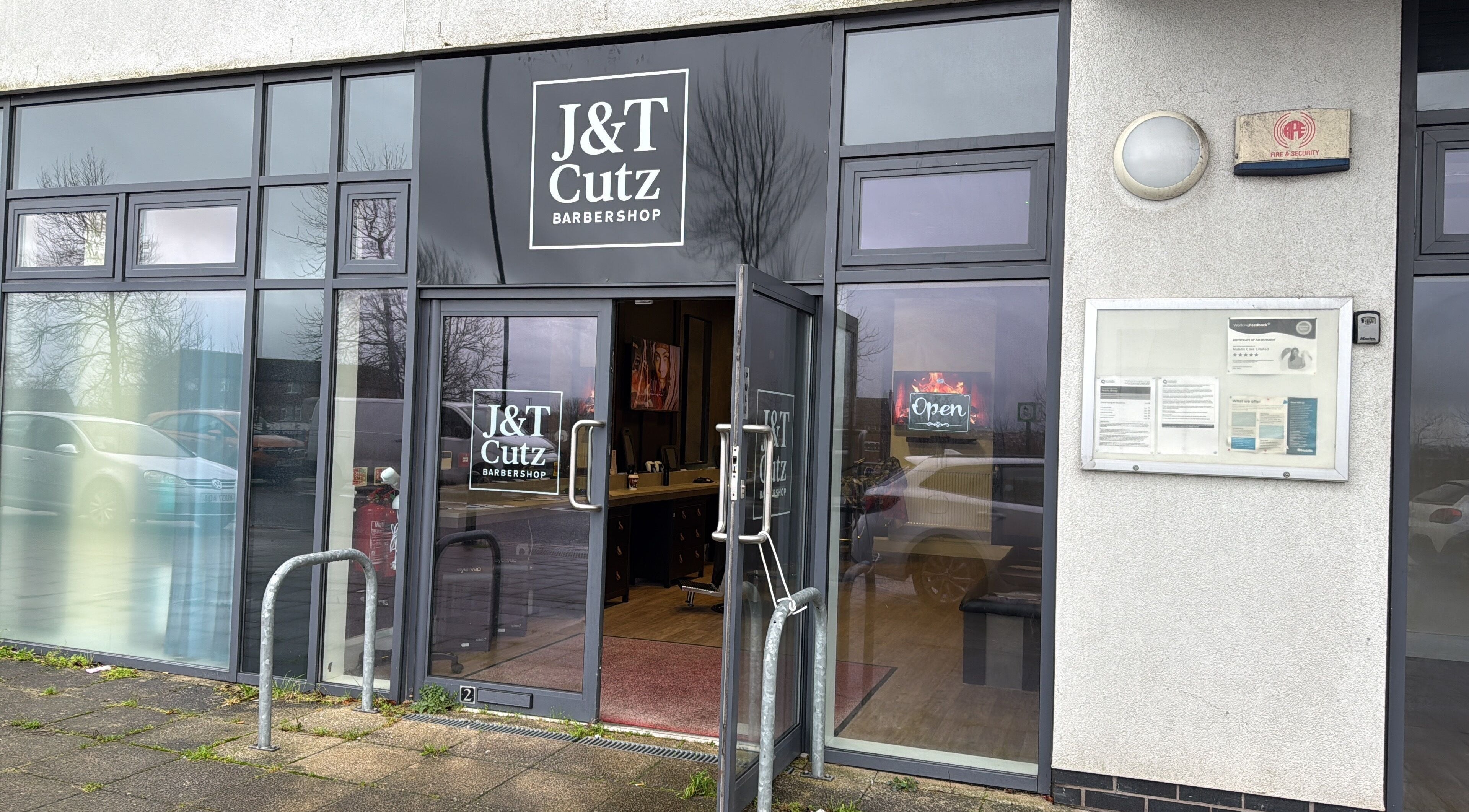 Front entrance of J&T Cutz LTD in Bristol, England, GB with glass doors and signage.