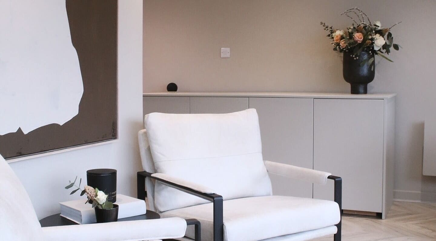 A cozy seating area at Jean Walker PMU, Harrogate, England, GB, featuring elegant decor and floral arrangement.