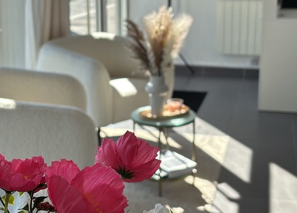 Intérieur lumineux d'Une Fille Vanille, Le Havre, Normandie, FR avec des fleurs et fauteuils.