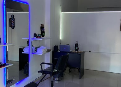 Interior moderno del salón Estilo Sosa en Rosario, Santa Fe, AR con espejo iluminado y estación de barbero.