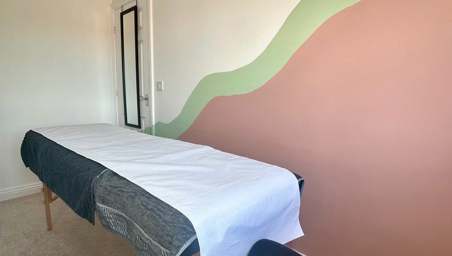 Serene treatment room at 33 Beauty and Aesthetics, Ilkeston, England, GB with mural wall and therapy bed.