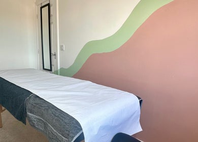 Serene treatment room at 33 Beauty and Aesthetics, Ilkeston, England, GB with mural wall and therapy bed.