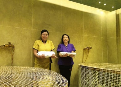 Staff at Third Eye Peace Spa in Dubai, AE, holding towels in a luxurious tiled room.