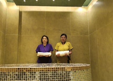 Warm and welcoming staff at Third Eye Peace Spa, Dubai, AE, holding white towels in a tranquil setting.