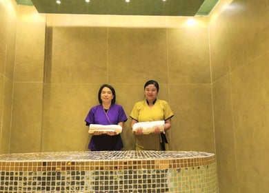Two staff members with towels at Third Eye Peace Spa, Dubai, AE, in a warm stone and tile setting.