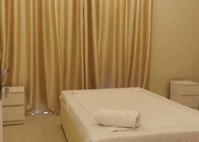 Calm treatment room at Third Eye Peace Spa, Dubai, AE with cozy bed and elegant curtains.