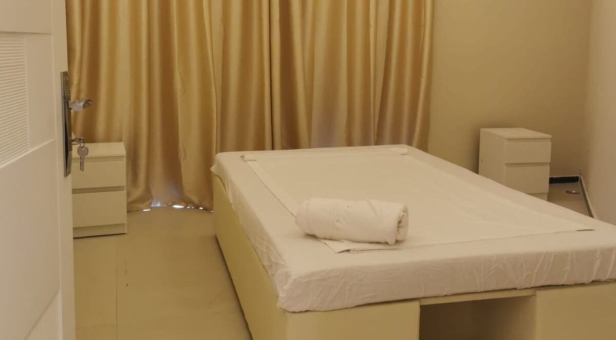Tranquil massage room at Third Eye Peace Spa Al Jaddaf, Dubai, AE with cozy bed and plush curtains.