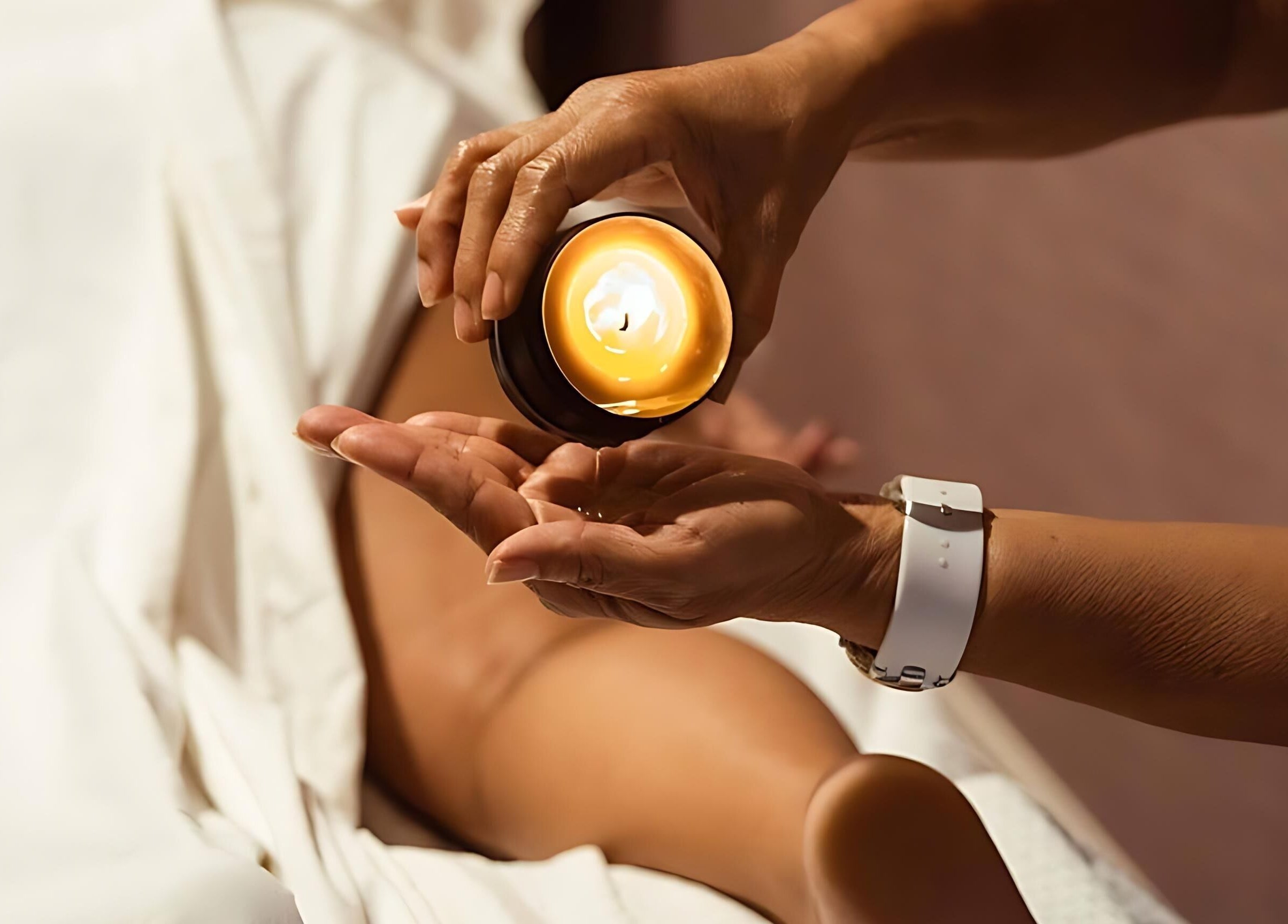 Relaxing massage at Sirena Island Spa, Noord, Oranjestad, AW with warm candle oil poured on hands.