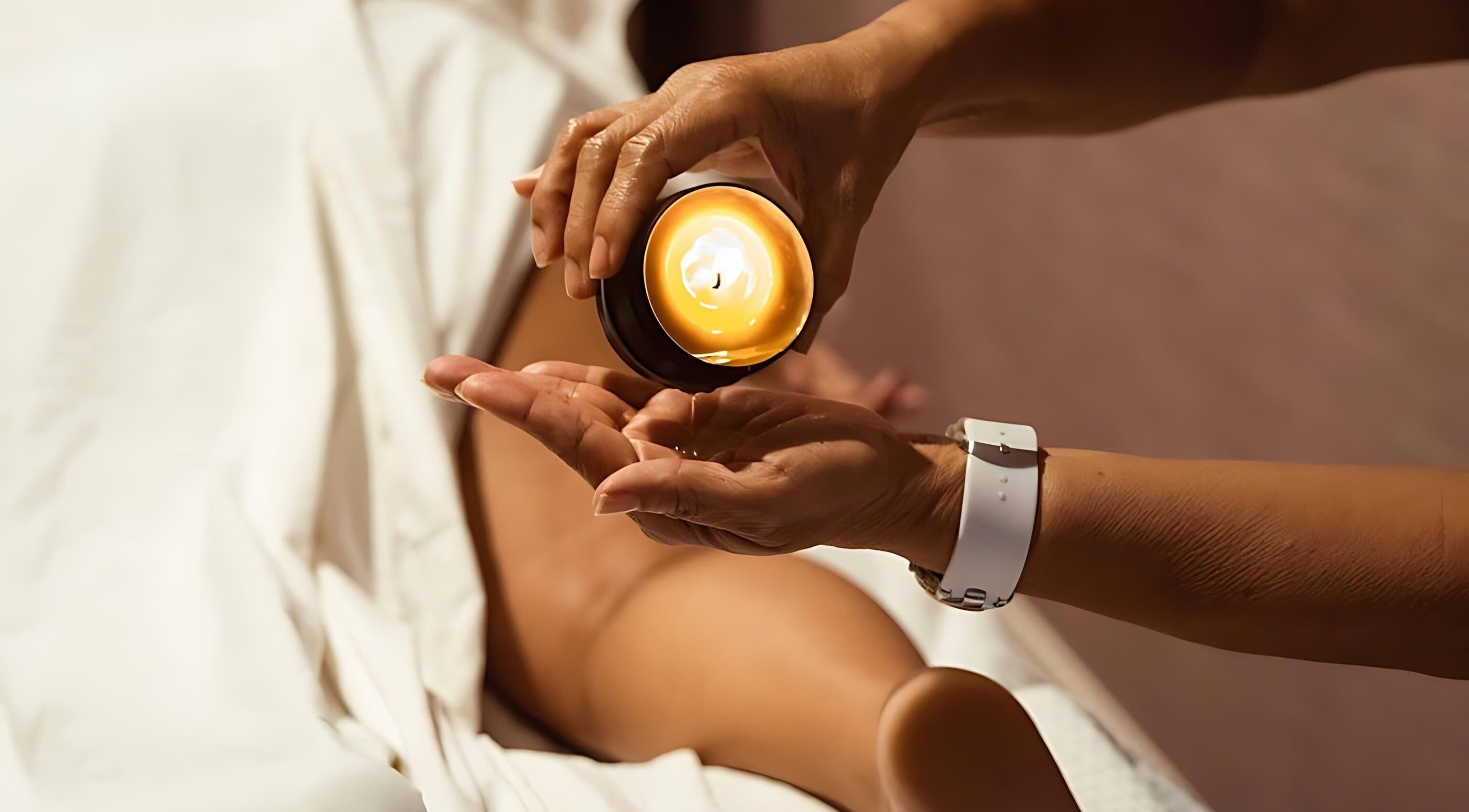 Relaxing massage at Sirena Island Spa, Noord, Oranjestad, AW with warm candle oil poured on hands.