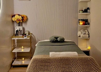 Tranquil massage room at Aura Sanctuary in New York, New York, US with a cozy table and soft lighting.